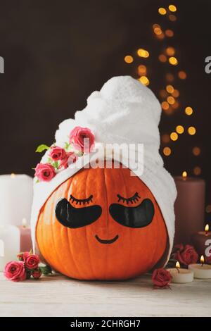 Candele e zucca con macchie sugli occhi su sfondo marrone Foto Stock