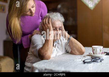 Giovane donna che passa il tempo con la nonna anziana a casa Foto Stock