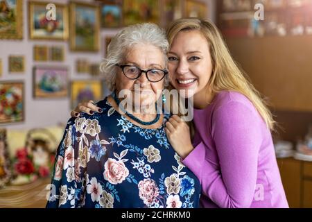 Giovane donna che passa il tempo con la nonna anziana a casa Foto Stock