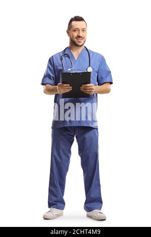 Ritratto a lunghezza intera di un medico maschile in un blu uniforme che tiene una clipboard e sorridente isolato su sfondo bianco Foto Stock