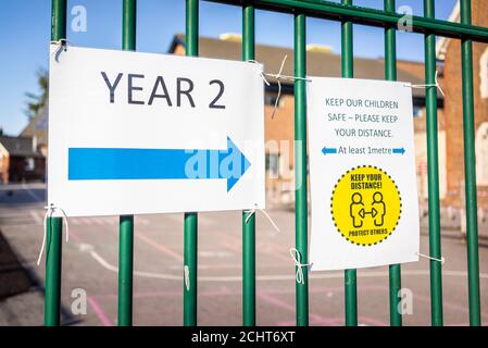 Southampton, Regno Unito. 14 settembre 2020. Covid-19 avviso sociale distancing segno di salvaguardia, 'tenere i nostri bambini al sicuro - mantenere la vostra distanza di almeno 1 m' in una recinzione vicino all'ingresso della Freemantle Community Primary School a Southampton, Hampshire, Inghilterra, Regno Unito Foto Stock