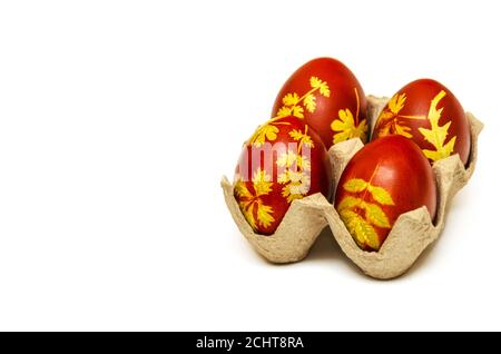 Uova di Pasqua tinte con bucce di cipolla con motivo di foglie fresche di piante su fondo bianco. Decorazione creativa e concetto fai da te. Primo piano Foto Stock