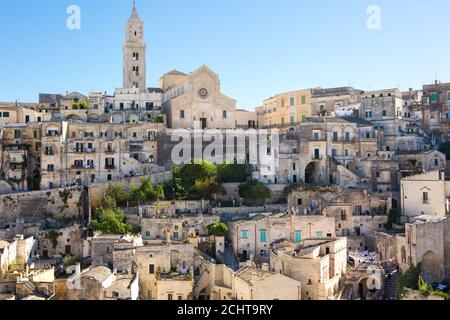 Vista delle case tipiche dell'antica città in pietra di Matera (Sassi di Matera), Basilicata, Italia. Sullo sfondo della Cattedrale di Matera. Foto Stock