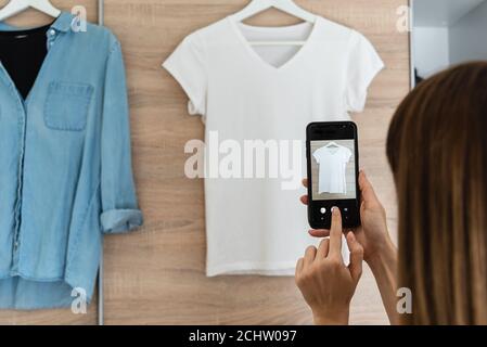 Donna che scattano foto di vestiti usati. Vendita di abbigliamento usato concetto Foto Stock