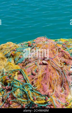 colorate reti da pesca che si asciugano al sole sulla parete del porto di zante, nel mar ionio in grecia. Foto Stock