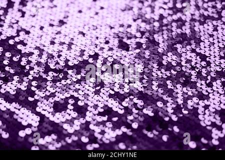 Tessuto a paillettes. Brillante sfondo argento brillante. Capo di abbigliamento con glitter metallizzato per una festa glamour, una festa. Primo piano. Immagine a toni Foto Stock