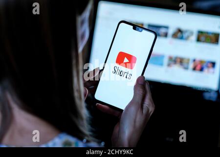 : YouTube Shorts app logo visto sullo smartphone che reggono da giovane ragazza. Si tratta di una nuova app video a ciclo breve, concorrente di TikTok, Bytes e Reels Foto Stock