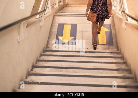 Giovane femmina scendendo scale con frecce Foto Stock