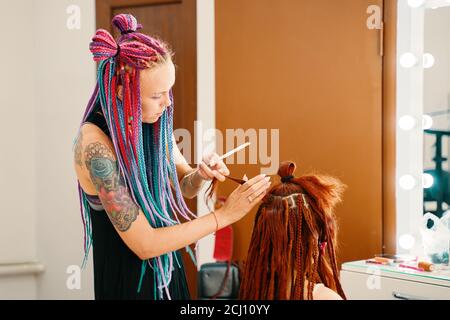 Barbiere trecce Dreadlock. Testa di ragazza con trecce dal materiale, capelli creativi con trecce spesse o pigtail anche conosciuto come African o African trecce. Bishkek, Kirghizistan - 04 luglio 2019 Foto Stock