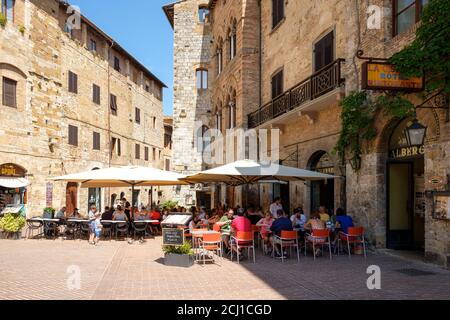 Turisti in un ristorante sulla città medievale di San Gimignano in Toscana Foto Stock