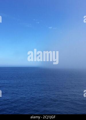 Oceano pacifico costiero al largo di Dunedin, fitta banca nebbia in mare a causa di quasi nessun vento durante il giorno, Nuova Zelanda, Isola del Sud Foto Stock