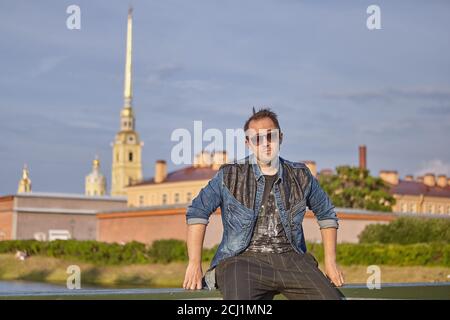 Un giovane in occhiali da sole sta viaggiando per San Pietroburgo, Russia. Viaggiatore maschio caucasico 27 anni. Foto Stock