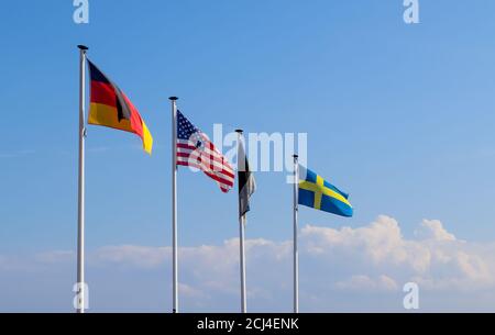 Fila di bandiere sui pali che ondolano nel cielo Foto Stock