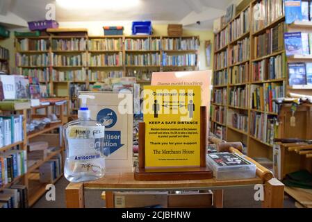 Un centro di antiquariato a Leominster, Herefordshire mostra i segni di allontanamento sociale e disinfettante per le mani tra le esposizioni del libro Foto Stock