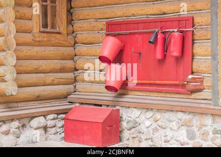 scudo di legno con utensili antincendio sulla parete della casa, primo piano Foto Stock