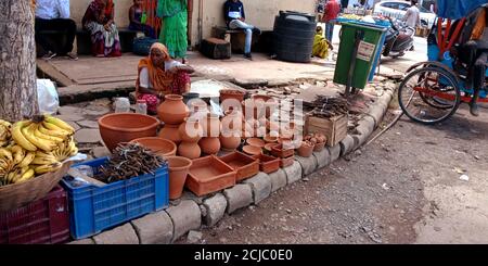 DISTRETTO KATNI, INDIA - 15 AGOSTO 2019: Una vecchia donna povera del villaggio indiano che vende la pentola del suolo sul mercato di strada. Foto Stock