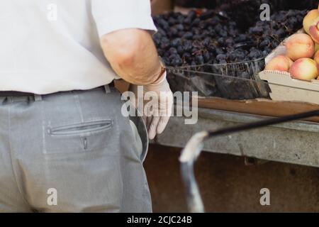 Uomo anziano con guanti igienici per prevenire l'infezione con il virus corona, shopping nel mercato machne yehuda prima delle vacanze Tishrei 2020 Foto Stock