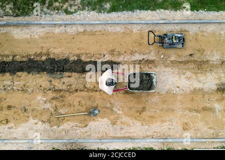 i lavoratori posano le piastrelle di pavimentazione vista dall'alto da un drone. Foto Stock