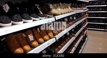 DISTRETTO KATNI, INDIA - 16 SETTEMBRE 2019: Scarpe di pelle di marca esposte a scaffali per la vendita di prodotti al mega-market store. Foto Stock