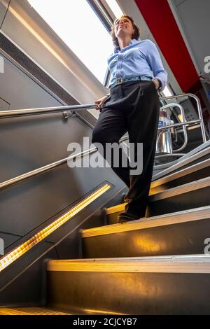 Donna in discesa su una scala in treno di prima classe in Svizzera. Foto Stock