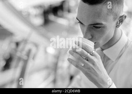 Giovane bell'uomo d'affari androgino che esplora la città Foto Stock