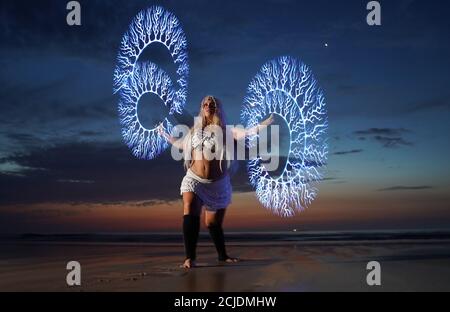 La coreografa Penella Bee di Bee-Enchanted, che si è cita al fuoco, pratica la sua routine sulla spiaggia di Seaburn a Sunderland questa mattina presto. Foto Stock