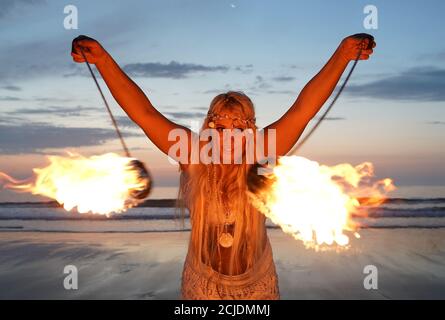 La coreografa Penella Bee di Bee-Enchanted, che si è cita al fuoco, pratica la sua routine sulla spiaggia di Seaburn a Sunderland questa mattina presto. Foto Stock