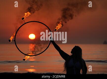 La coreografa Penella Bee di Bee-Enchanted, che si è cita al fuoco, pratica la sua routine sulla spiaggia di Seaburn a Sunderland questa mattina presto. Foto Stock