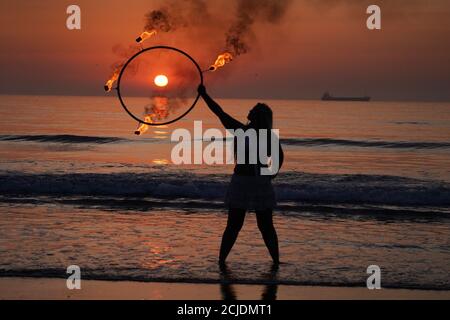 La coreografa Penella Bee di Bee-Enchanted, che si è cita al fuoco, pratica la sua routine sulla spiaggia di Seaburn a Sunderland questa mattina presto. Foto Stock