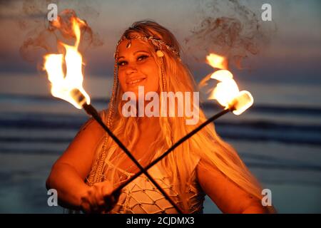 La coreografa Penella Bee di Bee-Enchanted, che si è cita al fuoco, pratica la sua routine sulla spiaggia di Seaburn a Sunderland questa mattina presto. Foto Stock