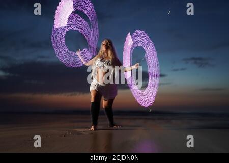 La coreografa Penella Bee di Bee-Enchanted, che si è cita al fuoco, pratica la sua routine sulla spiaggia di Seaburn a Sunderland questa mattina presto. Foto Stock