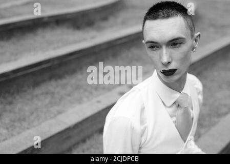 Giovane bell'uomo d'affari androgino che esplora la città Foto Stock