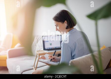 Ragazza in cuffia studente impara l'inglese online attraverso la videochiamata con insegnante su computer portatile internet Foto Stock