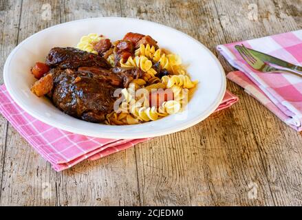 Ossobuco piatto italiano con scanchi di manzo brasati, verdure e pasta Foto Stock