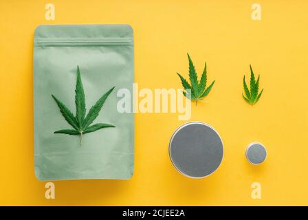 Pacchetto verde artigianale con foglie di cannabis e vasi di metallo. Diverse misure di Cannabis Packages, legalizzazione del commercio delle erbe infestate. Farmacia farmaci marijuana medica Foto Stock