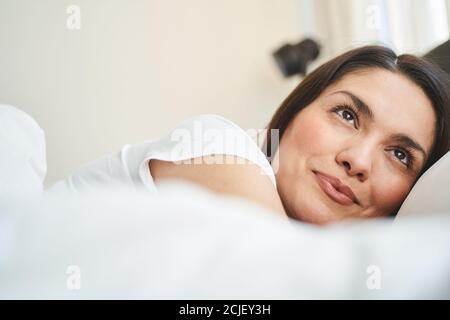 Donna che sogna a letto al mattino Foto Stock