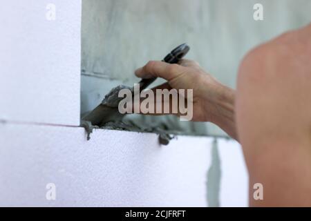 Isolamento a parete con pannelli in polistirene, applicazione e installazione di colla. Foto Stock