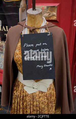 "Indossa la maschera prima di entrare nel negozio", all'esterno del negozio di abbigliamento d'epoca Armstrongs nel Grassmarket, Edimburgo, Scozia, Regno Unito. Foto Stock