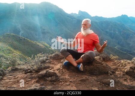 Uomo anziano saluto tramonto Foto Stock