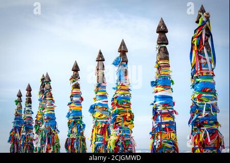 Colonne sacre con nastri legati a Capo Burhan dell'Isola di Olkhon. Tradizioni Buryat. Riti sciamanistici e buddici del lago Baikal. Olkhon Island, Baika Foto Stock