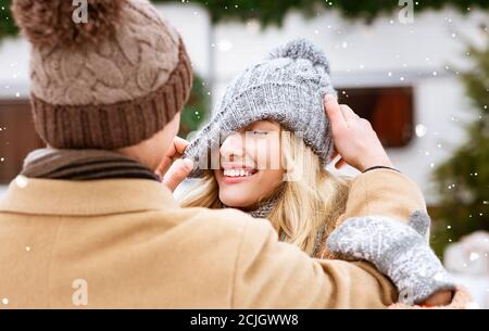 Una romantica coppia millenaria che si diverte all'aperto durante il giorno invernale delle nevi Foto Stock
