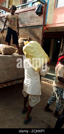 DISTRETTO KATNI, INDIA - 12 AGOSTO 2019: Un uomo asiatico ha trasportato il sacco vegetale sulla testa dopo l'acquisto di merci fresche di agricoltura verde sul mercato. Foto Stock