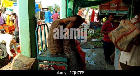 DISTRETTO KATNI, INDIA - 12 AGOSTO 2019: Un uomo asiatico ha trasportato sacco vegetale con sforzi manuali dopo l'acquisto di merci fresche di agricoltura verde sul mercato. Foto Stock