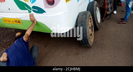 DISTRETTO KATNI, INDIA - 17 AGOSTO 2019: Il conduttore asiatico del bus che cambia la gomma del bus sulla strada durante il trasporto all'autostrada nazionale di Jabalpur. Foto Stock