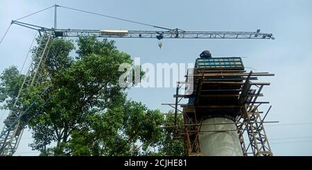 DISTRETTO KATNI, INDIA - 17 AGOSTO 2019: Operaio del comune indiano che fa sopra il ponte durante i lavori di costruzione del luogo di strada. Foto Stock