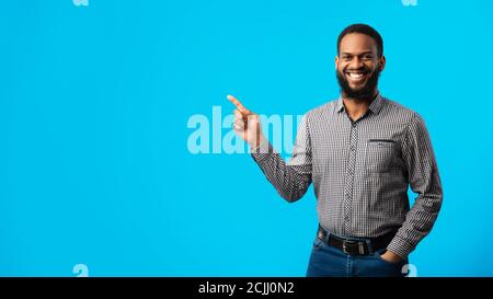 Ragazzo nero sorridente che indica da parte lo spazio di copia Foto Stock