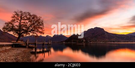 Tramonto spettacolare ad Annecy. Nuvole arancioni e rosse e un lago nelle Alpi francesi Foto Stock