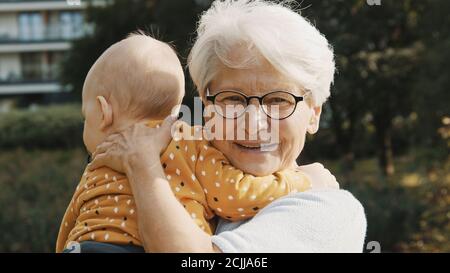 primo piano, felice nonna abbracciando il nipote in natura. Foto di alta qualità Foto Stock