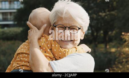 Nonna felice che tiene il suo nipote nella natura. Foto di alta qualità Foto Stock