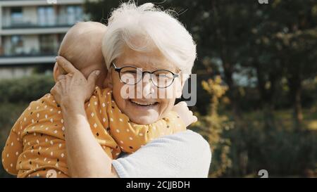 Nonna felice abbracciando suo nipote in natura. Legame familiare ed emozioni. Foto di alta qualità Foto Stock